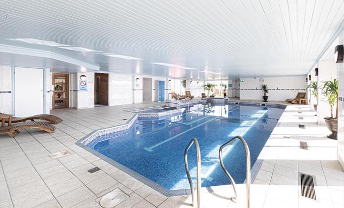 Image of The Beaches Hotel and Spa swimming pool, shoing the sun loungers fround the side of the pool and the sauna.